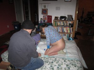 Moments before her birth. You can see the doppler in front of me, because I suddenly got freaked out about needing to listen to her heartbeat. My husband is wearing a hat because it is January and we heat with wood, but were busy having a baby instead of tending a fire! 